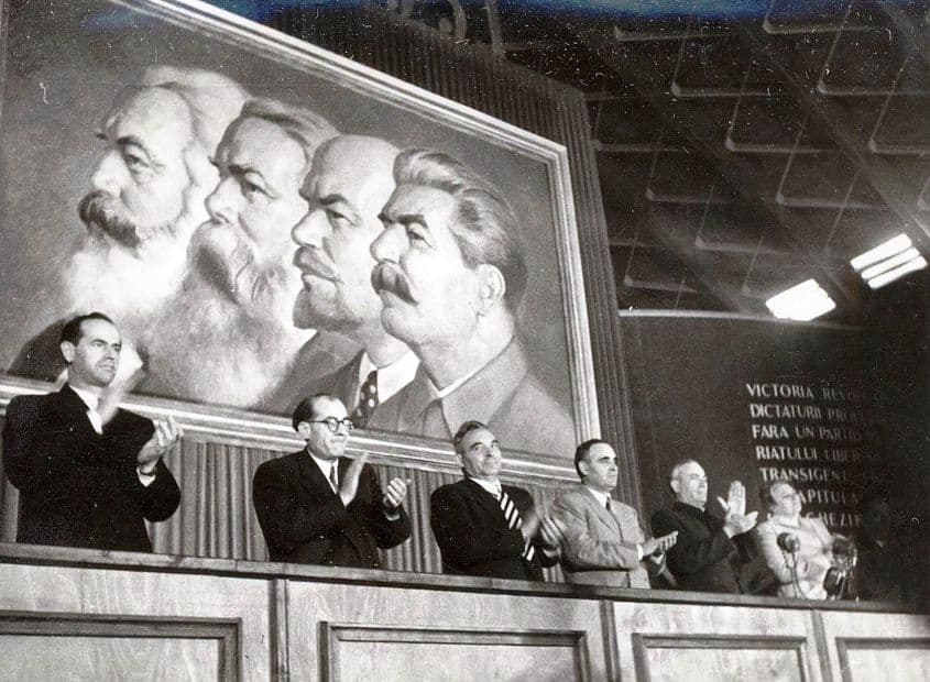 1951. România. Un prezidiu cu oficiali comuniști, în frunte cu Gheorghe Gheorghiu-Dej (în costum gri), sub imaginea iconică a cvartetului Stalin-Lenin-Engels-Marx. Foto: Fototeca online a comunismului românesc