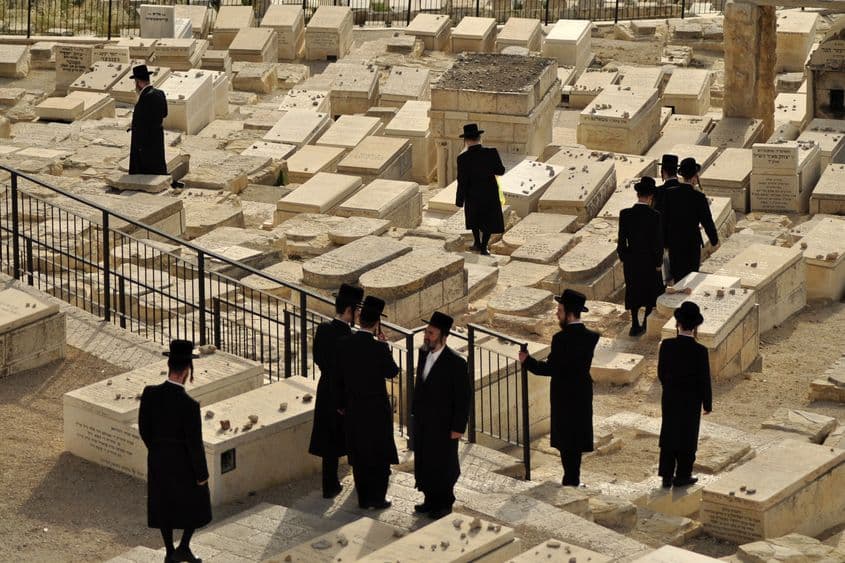 Evrei ultra-ortodocși așază pietre de aducere aminte pe morminte dintr-un cimitir situat pe Valea Chedronului.