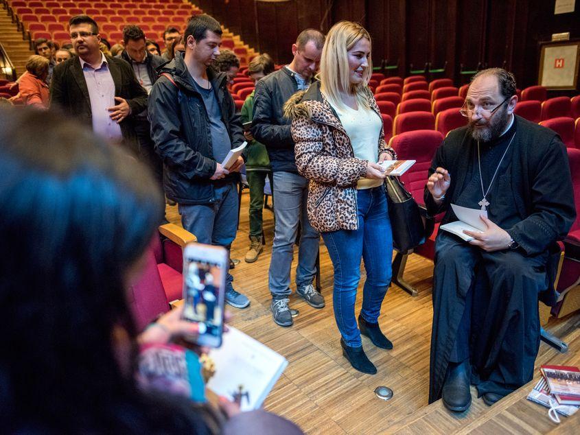 Părintele Constantin Necula, dând autografe după o conferință susținută la Cluj. Foto: Raul Ștef