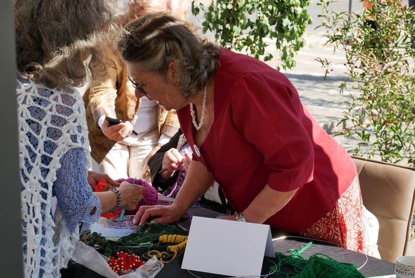 Victorina Enciu, 71 de ani, lucrează la un fular început de altcineva, în timpul atelierului de croșetat din Piața Revoluției. FOTO: Norbert Nemeș