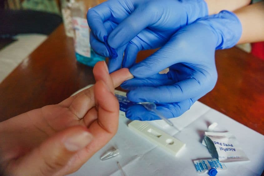 Pasul unu: după dezinfectarea suprafeței pielii, se înțeapă un deget cu un ac special, parte din kitul de testare, pentru a obține câteva picături de sânge