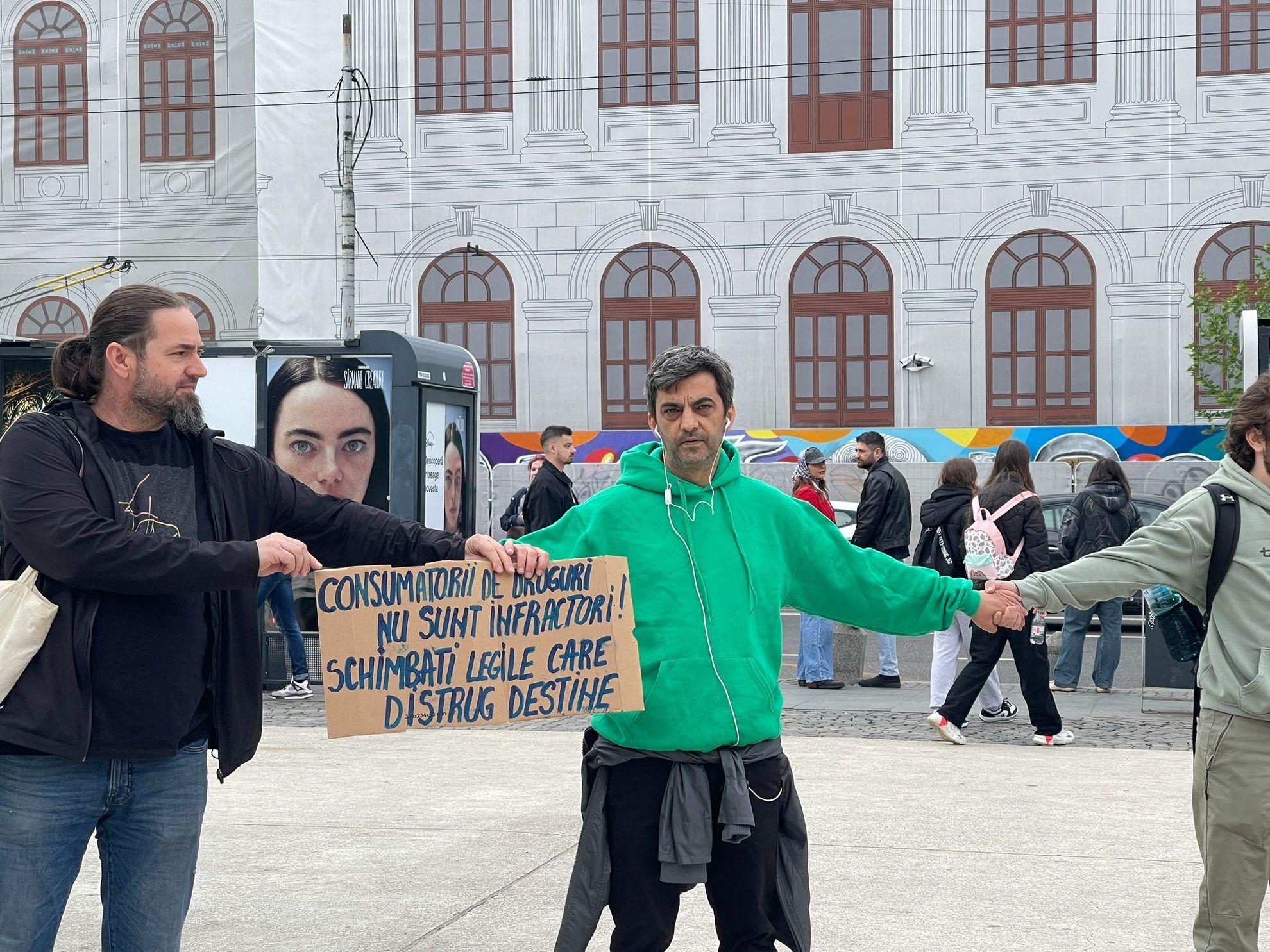O pancartă pe care scrie „Consumatorii de droguri nu sunt infractori! Schimbați legile care distrug destine” este plimbată din mână în mână în interiorul cercului. Foto: Lavinia Niță / PressOne