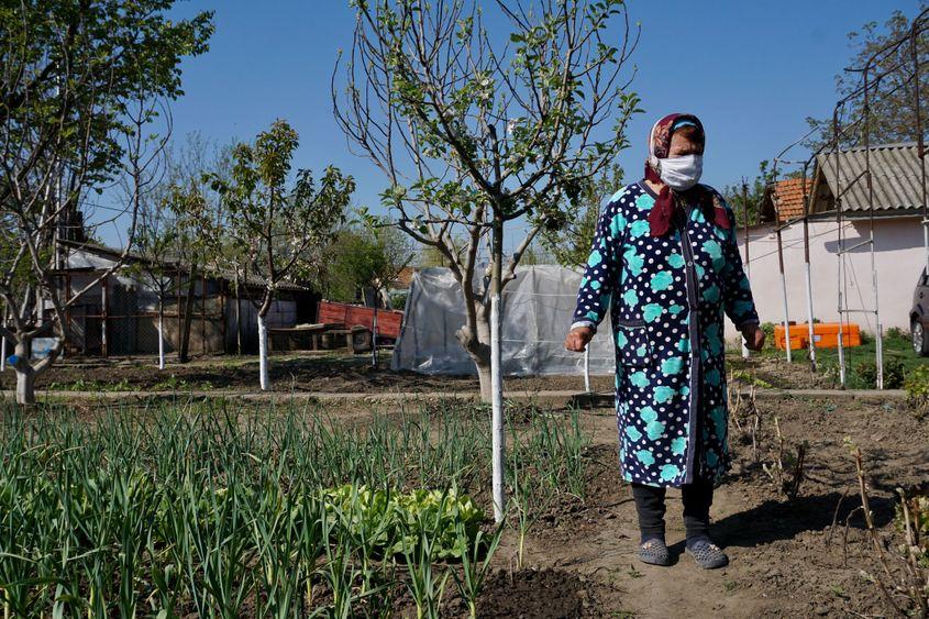 "Le punem, mamă, dar ni s-a urât, cât să stai cu botelnițele alea la gură?", se întreabă cu  necaz tanti Măruța, punându-și pe nas și gură masca improvizată de fata ei. Foto: Maria Tufan