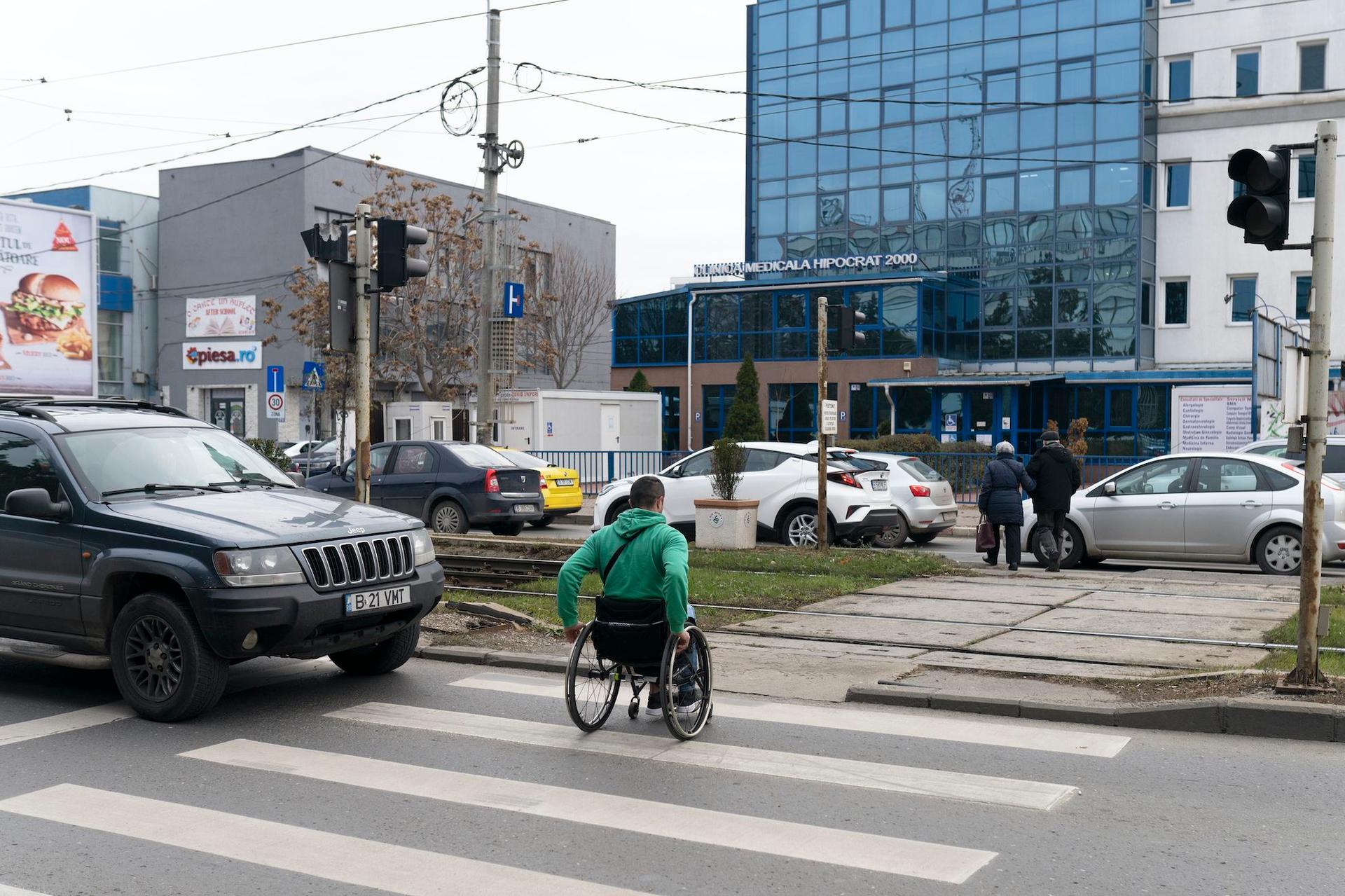 Angel Moraru, care se deplasează în scaun rulant, demonstrează cum se poate mișca pe o stradă din București. Sau, mai degrabă, care sunt obstacolele. Foto: Andreea Câmpeanu