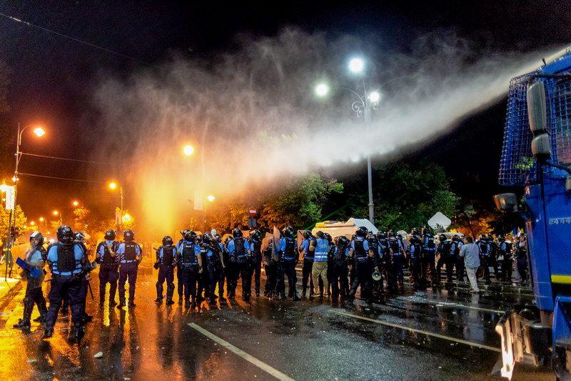 „Un tun cu apă este folosit de forțele de ordine pentru a dispersa populația prezentă în prima zi de proteste ale românilor din diaspora față de guvernul PSD, în Piața Victoriei din București, vineri, 10 August 2018.” Inquam Photos / Liviu Florin Albei