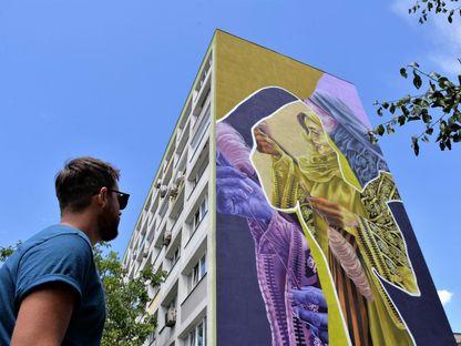 Artistul care și-a pictat iubita pe un bloc: Aş desena toate clădirile comuniste din oraş