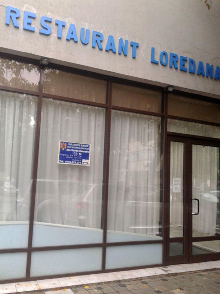 Pe geamul restauranului, un mic afiș anunță că în clădire e biroul senatoarei Jipa