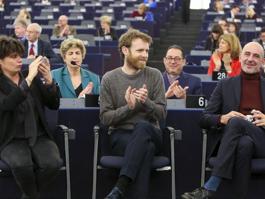 Scenaristul Philippe Mangeot (în dreapta), alături de producătoarea Marie-Ange Luciani și de actorul Antoine Reinartz, la festivitatea din Parlamentul European.