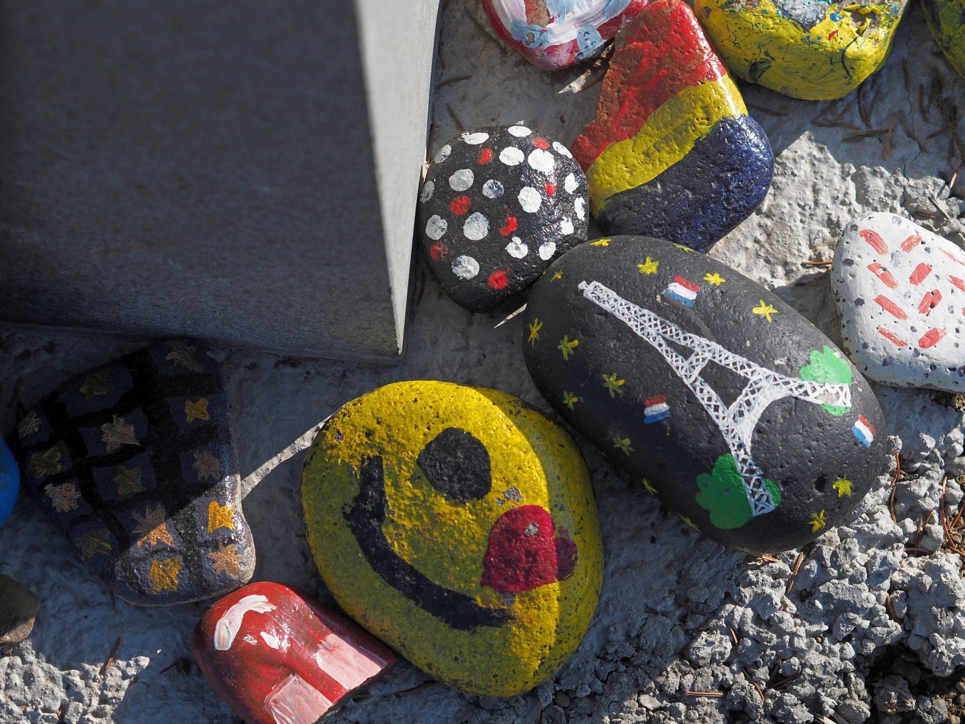 La poalele unei borne, copiii au lăsat niște pietre de aducere aminte pictate cu ce au simțit ei.