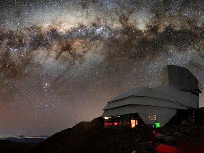 This image captures not only Vera C. Rubin Observatory, a Program of NSF NOIRLab, but one of the celestial specimens Rubin Observatory will observe when it comes online: the Milky Way. The bright halo of gas and stars on the left side of the image highlights the very center of the Milky Way galaxy. The dark path that cuts through this center is known as the Great Rift, because it gives the appearance that the Milky Way has been split in half, right through its center and along its radial arms. In fact, the Great Rift is caused by a shroud of dust, which blocks and scatters visible light. This dust makes the Great Rift a difficult space to observe. Fortunately, Rubin is being built to conduct the Legacy Survey of Space and Time (LSST). This survey will observe the entire visible southern sky every few nights over the course of a decade, capturing about 1000 images of the sky every night and giving us a new view of our evolving Universe. The LSST is set to probe four areas of science, one of which is mapping the Milky Way to answer questions about its structure and formation. Once Rubin Observatory comes online in 2024, scientists will be able to access the data taken every night of operation. Rubin Observatory is a joint initiative of the National Science Foundation and the Department of Energy (DOE). Once completed, Rubin will be operated jointly by NSF NOIRLab and DOE's SLAC National Accelerator Laboratory to carry out the Legacy Survey of Space and Time.