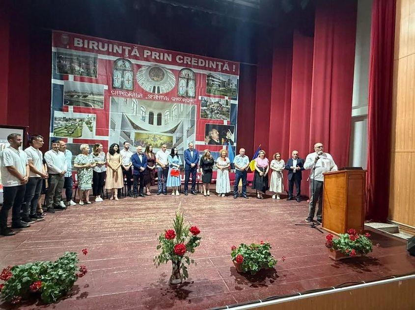 Preotul Dan Pavel vorbește în prezența lui Marian Neacșu la conferința la care a fost ales președinte al filialei PSD Topoloveni, cu sloganul „Biruință prin credință”. Foto: Facebook/PSD Argeș