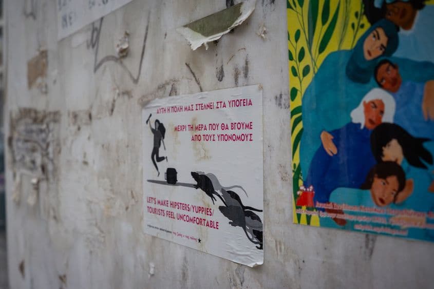 „Acest oraș ne trimite să trăim în subsol. Până în ziua în care vom ieși din canalizare. Să-i facem pe hipsteri/yuppies/turiști să se simtă inconfortabil." Semn în cartierul Koukaki din Atena, unul dintre cartierele care suferă cel mai rău din cauza turistificării și gentrificării. Foto: Ioana Epure