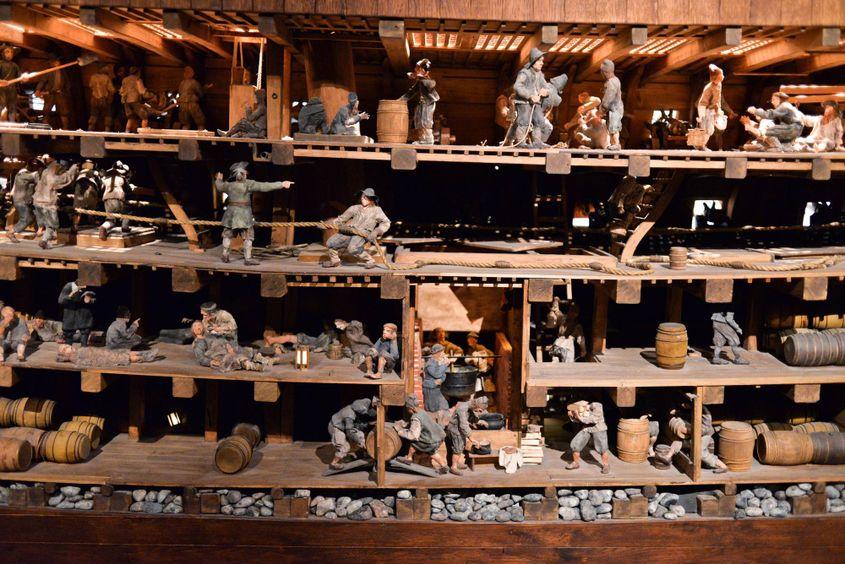 Machetă în care se disting încărcătura navei și activități de la bord.