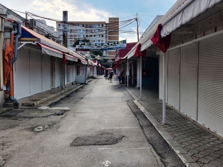 Piața Veteranilor, la aproape trei ore de la terminarea programului. În plan îndepărtat, câteva femei au rămas să vândă fructe și flori. FOTO: Călin Căciuleanu