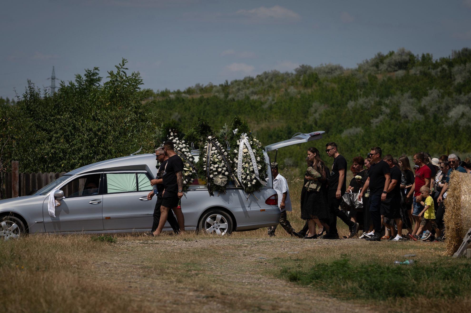 Oamenii merg spre cimitir în timpul funeraliilor lui Petru Cosmin Samolinschi, care a fost ucis în Goma, într-un sat de lângă orașul Iași, în România, pe 20 iunie 2024. Foto: Andreea Câmpeanu