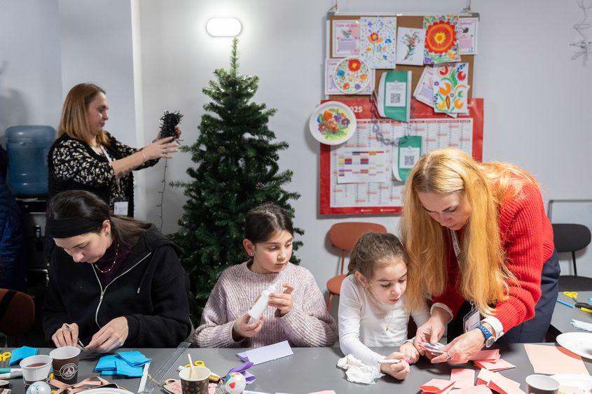 Împodobirea bradului de Crăciun la biroul ASSOC din Baia Mare, împreună cu câțiva copii sirieni. Foto: Raul Ștef